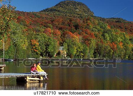 Vermont, On a sunny fall day mother and daughter sit peacefully together relaxing on a dock reflecting in Long Pond of Westmore. View Large Photo Image Stock Image - Vermont, On a sunny fall day mother and daughter sit peacefully together relaxing on a dock reflecting in Long Pond of Westmore.. Fotosearch