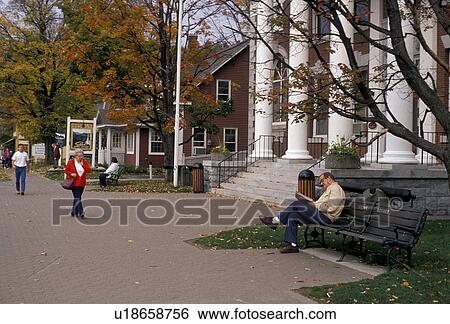 Vermont, Stowe, Man reading the paper on a bench near the Memorial Building in the scenic village of Stowe in the fall. A winter and summer resort town View Large Photo Image Stock Photograph - Vermont, Stowe, Man reading the paper on a bench near the Memorial Building in the scenic village of Stowe in the fall. A winter and summer resort town . Fotosearch