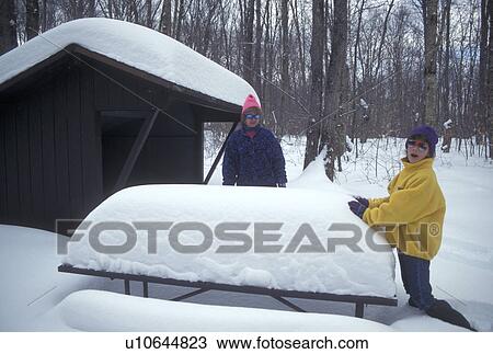 Stock Image -  Vermont, VT, Mother and daughter visit a snow-covered campsite in Groton State Forest in winter . Fotosearch