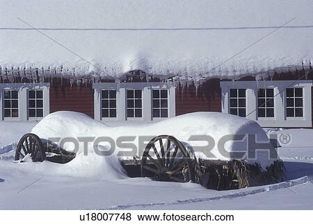 Stock Photo -  Vermont, VT, Snow-covered wagon and red barn in the winter in East Topsham. Icicles hang from the barn., . Fotosearch