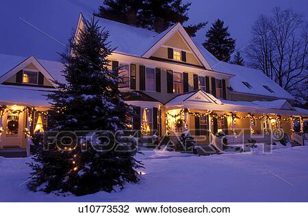 Stock Image -  Vermont, Woodstock, B&B, inn, Christmas, The Jackson House Inn is illuminated with Christmas decorations on a snow covered [night, evening] in West Woodstock.. Fotosearch
