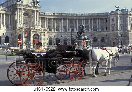 Stock Image -  Vienna, horse and carriage, Austria, Europe, Horse and carriage waiting for passengers standing in front of the Imperial Palace (Hofburg) in downtown Vienna.. Fotosearch