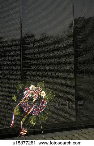 Stock Image -  Vietnam Veterans Memorial Wall, Washington, Vietnam Memorial, DC, District of Columbia, capital city, A wreath is placed by a loved one who served and died in the Vietnam War on the black granite wall of the Vietnam Veterans Memorial in the nation's capi. Fotosearch