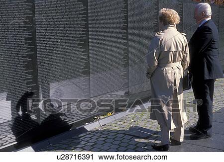 Vietnam Veterans Memorial Wall, Washington, DC, District of Columbia, Couple looking at names of loved ones who died in the Vietnam war on the V-shaped black granite wall of the Vietnam Veterans Memorial in Washington, D. C. View Large Photo Image Stock Image - Vietnam Veterans Memorial Wall, Washington, DC, District of Columbia, Couple looking at names of loved ones who died in the Vietnam war on the V-shaped black granite wall of the Vietnam Veterans Memorial in Washington, D. C.. Fotosearch