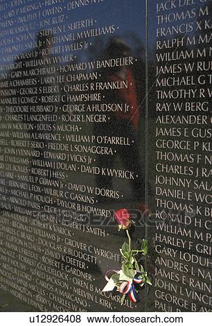 Stock Photo -  Vietnam Veterans Memorial Wall, Washington, DC, District of Columbia, Red rose placed next to loved one who died in the Vietnam war on the V-shaped black granite wall of the Vietnam Veterans Memorial in Washington, D. C.. Fotosearch
