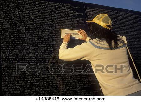 Vietnam Veterans Memorial Wall, Washington, DC, District of Columbia, Woman tracing loved ones name from the V-shaped black granite wall of the Vietnam Veterans Memorial in Washington, D. C. View Large Photo Image Stock Photography - Vietnam Veterans Memorial Wall, Washington, DC, District of Columbia, Woman tracing loved ones name from the V-shaped black granite wall of the Vietnam Veterans Memorial in Washington, D. C.. Fotosearch