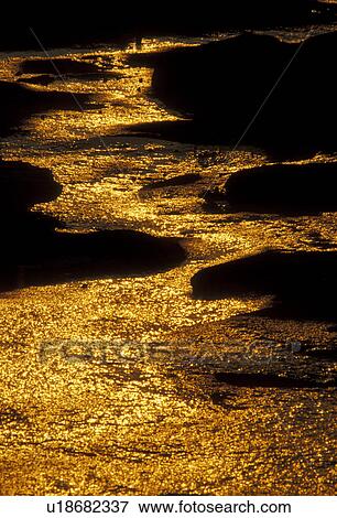 Stock Photo -  water, gold, sunrise, sunset, Georgia, A stream of water the color of gold flows down Stone Mountain at [sunrise, sunset] in Georgia's Stone Mountain Park. . Fotosearch