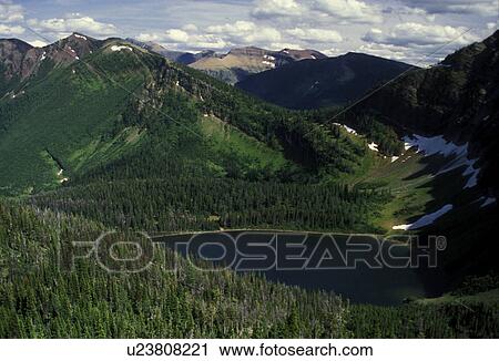 Stock Image -  Waterton Lakes National Park, Alberta, Canada, Canadian Rockies, glacier lake, mountains, A scenic view of Twin Lake and the surrounding mountains with patches of snow in Waterton-Glacier International Peace Park.. Fotosearch