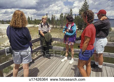Yellowstone National Park, geyser, ranger, West Thumb Geyser Basin, Wyoming, Yellowstone, A small group of people listen to a ranger talk while standing on a wooden boardwalk at the West Thumb Geyser Basin in Yellowstone National Park in the state of Wyo View Large Photo Image Picture - Yellowstone National Park, geyser, ranger, West Thumb Geyser Basin, Wyoming, Yellowstone, A small group of people listen to a ranger talk while standing on a wooden boardwalk at the West Thumb Geyser Basin in Yellowstone National Park in the state of Wyo. Fotosearch
