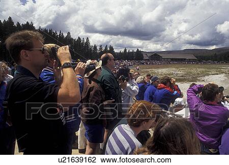 Stock Image -  Yellowstone National Park, Old Faithful, Wyoming, Yellostone, Tourists gather to watch The Old Faithful Geyser erupt in Yellowstone National Park in the state of Wyoming. . Fotosearch