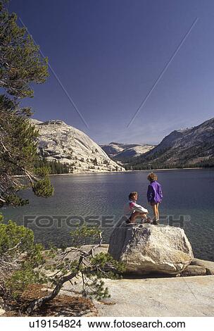 Yosemite, Yosemite National Park, Tenaya Lake, hiking, Sierra Nevada Mountains, California, Mother and daughter (7 years old) take a break from hiking and (sit, stand) on a boulder next to Tenaya Lake in Yosemite Nat'l Park in the state of California. View Large Photo Image Picture - Yosemite, Yosemite National Park, Tenaya Lake, hiking, Sierra Nevada Mountains, California, Mother and daughter (7 years old) take a break from hiking and (sit, stand) on a boulder next to Tenaya Lake in Yosemite Nat'l Park in the state of California.. Fotosearch