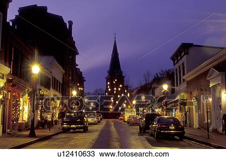 Stock Image -  Annapolis, Maryland, MD, Christmas decorations along Main Street in downtown Annapolis in the evening. View of St. Anne's Church in the background.. Fotosearch