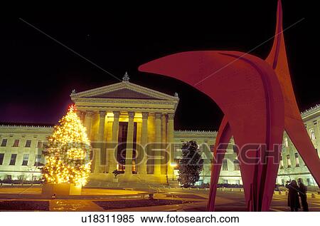Stock Photography -  art museum, Philadelphia, Pennsylvania, PA, Red Calder sculpture and Christmas tree illuminated at night outside the Philadelphia Museum of Art in downtown Philadelphia.. Fotosearch