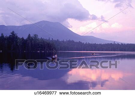 Stock Photo -  Baxter Park, Maine, Canoe, sunset, ME, People canoeing on the calm waters of Daicey Pond at sunset with Mt. Katahdin in the background in Baxter State Park.. Fotosearch
