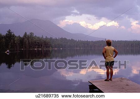Baxter Park, Maine, ME, Woman watching people canoe on the calm waters of Daicey Pond at sunset in Baxter State Park. Mt. Katahdin in the background. View Large Photo Image Stock Photography - Baxter Park, Maine, ME, Woman watching people canoe on the calm waters of Daicey Pond at sunset in Baxter State Park. Mt. Katahdin in the background.. Fotosearch