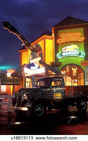 Stock Image -  Branson, banjo, country music, MO, Missouri, World's Largest Banjo displayed at the Grand Country Square in Branson in the evening and antique truck.. Fotosearch