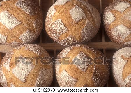 bread, bakery, loaf, fresh, round, close up, background, A close-up of freshly baked small round country loaves are displayed on the wooden cooling racks at Gerard's Bakery in Westford in the state of Vermont. View Large Photo Image Stock Photo - bread, bakery, loaf, fresh, round, close up, background, A close-up of freshly baked small round country loaves are displayed on the wooden cooling racks at Gerard's Bakery in Westford in the state of Vermont. . Fotosearch