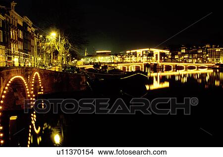bridge, canal, Amsterdam, The Netherlands, Holland, Europe, The bridges that cross the canals (grachten) are illuminated at night in downtown Amsterdam. View Large Photo Image Picture - bridge, canal, Amsterdam, The Netherlands, Holland, Europe, The bridges that cross the canals (grachten) are illuminated at night in downtown Amsterdam. . Fotosearch