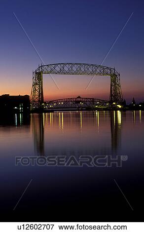 Stock Photo -  bridge, Duluth, MN, Minnesota, Aerial Lift Bridge, 386 feet long, at sunrise spans the Duluth Harbor on Lake Superior in Duluth.. Fotosearch