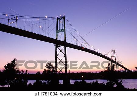 Picture -  bridge, Thousand Islands, NY, International Bridge, Alexandria Bay, New York, St. Lawrence River, International Bridge at sunset crosses the St. Lawrence River into Ontario, Canada.. Fotosearch