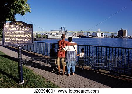 Buffalo, New York, NY, Family looking out across the Buffalo River near an Historical marker at Esplanade Park in Buffalo. Birthplace of the Grain Elevator. View Large Photo Image Stock Photo - Buffalo, New York, NY, Family looking out across the Buffalo River near an Historical marker at Esplanade Park in Buffalo. Birthplace of the Grain Elevator.. Fotosearch