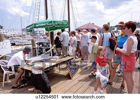 Stock Image -  Camden, harbor, Maine, ME, People standing on pier ready to board a tourboat in Penobscot Bay in Camden.. Fotosearch