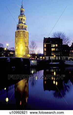 canal, Amsterdam, clock tower, Holland, The Netherlands, Europe, The illuminated clock tower reflects in the calm waters of the canal (grachten) in downtown Amsterdam at night View Large Photo Image Stock Image - canal, Amsterdam, clock tower, Holland, The Netherlands, Europe, The illuminated clock tower reflects in the calm waters of the canal (grachten) in downtown Amsterdam at night. Fotosearch