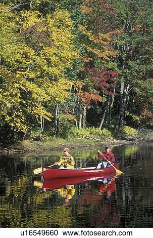 Stock Image -  canoe, canoeing, Vermont, VT, Mother and daughter paddle a red canoe on the calm water of Green River Reservoir in Hyde Park in the fall. . Fotosearch