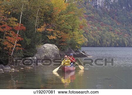 Stock Image -  canoe, canoeing, Vermont, VT, Mother and daughter paddling a red canoe on Lake Willoughby in Westmore in the fall. . Fotosearch