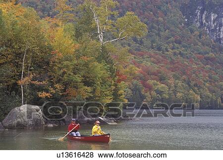 Stock Photo -  canoe, canoeing, Vermont, VT, Mother and daughter paddling a red canoe on Lake Willoughby in Westmore in the fall. . Fotosearch