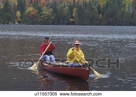 Stock Photography -  canoe, canoeing, Vermont, VT, Mother and daughter paddling a red canoe on Jobs Pond in Westmore in the fall. . Fotosearch