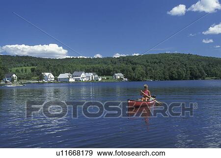 Stock Photo -  canoe, canoeing, Vermont, VT, Woman paddling a red canoe on Lake Elmore. . Fotosearch