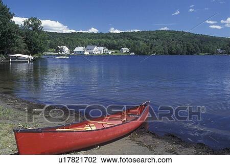 Stock Image -  canoe, Vermont, VT, red canoe on beach at Lake Elmore State Park.. Fotosearch