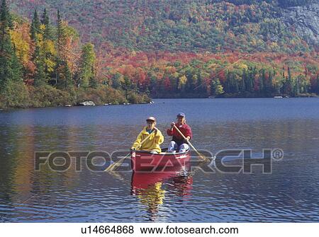 canoeing, autumn, Vermont, VT, Mother and daughter paddle a red canoe on Marshfield Pond surrounded by colorful foliage in the fall. View Large Photo Image Stock Photo - canoeing, autumn, Vermont, VT, Mother and daughter paddle a red canoe on Marshfield Pond surrounded by colorful foliage in the fall. . Fotosearch