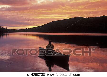canoeing, canoe, sunset, sunrise, Vermont, VT, Woman paddling a canoe on Kettle Pond at sunset in Groton State Forest. View Large Photo Image Stock Photo - canoeing, canoe, sunset, sunrise, Vermont, VT, Woman paddling a canoe on Kettle Pond at sunset in Groton State Forest.. Fotosearch