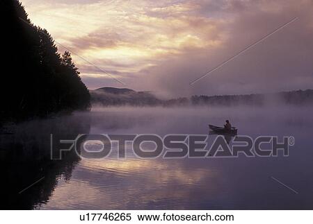 canoeing, canoe, sunset, sunrise, Vermont, VT, Woman paddling a canoe on Mollys Falls Pond at sunrise in the fog. View Large Photo Image Stock Photography - canoeing, canoe, sunset, sunrise, Vermont, VT, Woman paddling a canoe on Mollys Falls Pond at sunrise in the fog.. Fotosearch