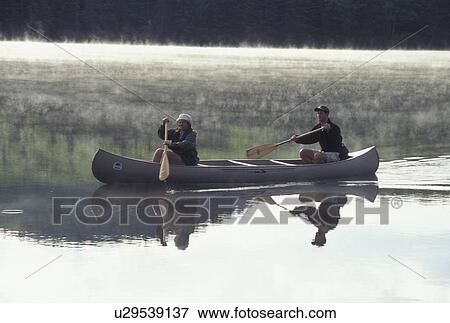 Stock Photo -  canoeing, canoe, Vermont, VT, A couple paddling a canoe on Osmore Pond in Groton State Forest.. Fotosearch