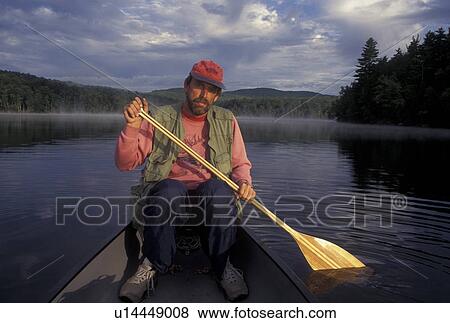 Stock Photo -  canoeing, canoe, Vermont, VT, Man paddling a red canoe on Green River Reservoir in Hyde Park. . Fotosearch