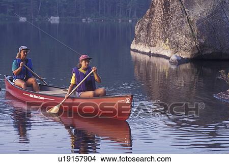 Picture -  canoeing, canoe, Vermont, VT, Mother and daughter paddling a red canoe next to a boulder on Kettle Pond in Groton State Forest.. Fotosearch