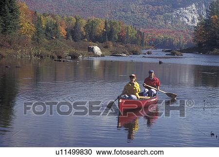 canoeing, canoe, Vermont, VT, Mother and daughter paddling a red canoe on Marshfield Pond in the fall. View Large Photo Image Stock Image - canoeing, canoe, Vermont, VT, Mother and daughter paddling a red canoe on Marshfield Pond in the fall. . Fotosearch