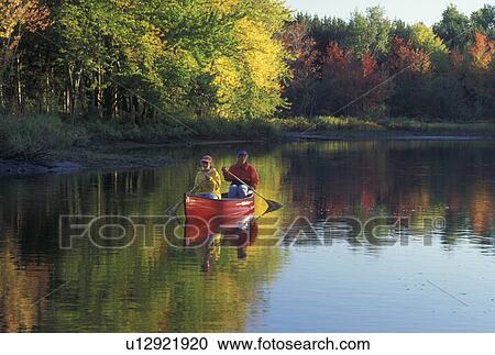 Stock Image -  canoeing, canoe, Vermont, VT, Mother and daughter paddling a red canoe down Clyde River in Charleston in the fall. . Fotosearch