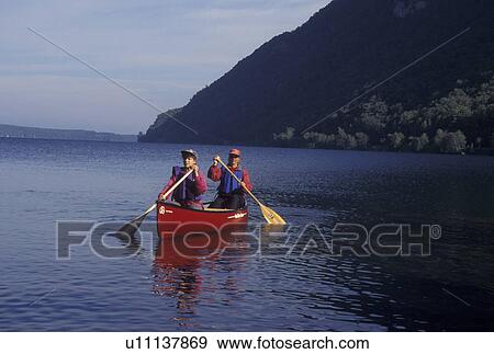 Stock Photo -  canoeing, canoe, Vermont, VT, Mother and daughter paddling a red canoe on Lake Willoughby in Westmore. Fotosearch