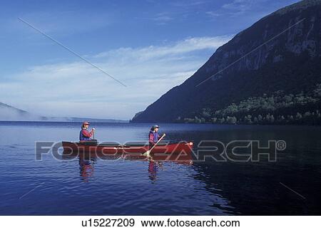 Stock Photo -  canoeing, canoe, Vermont, VT, Mother and daughter paddling a red canoe in the fog on Lake Willoughby in Westmore. Fotosearch