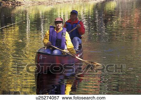 Stock Photo -  canoeing, canoe, Vermont, VT, Mother and daughter paddling a red canoe on Green River Reservoir in Hyde Park in the fall. . Fotosearch