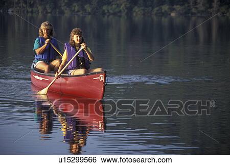 Stock Photograph -  canoeing, canoe, Vermont, VT, Mother and daughter paddling a red canoe on Kettle Pond in Groton State Forest.. Fotosearch