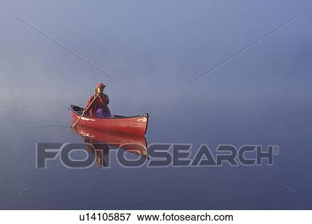 canoeing, canoe, Vermont, VT, Woman paddling a red canoe on Mollys Falls Pond at sunrise in the fog. View Large Photo Image Stock Photo -  canoeing, canoe, Vermont, VT, Woman paddling a red canoe on Mollys Falls Pond at sunrise in the fog.. Fotosearch