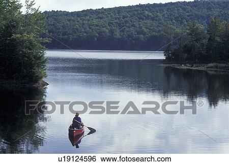 Stock Photograph -  canoeing, canoe, Vermont, VT, Woman canoeing on Green River Reservoir in Hyde Park. . Fotosearch