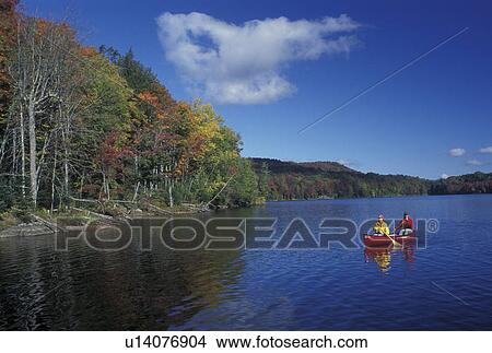 Picture -  canoeing, Vermont, VT, Mother and daughter paddle a red canoe on Green River Reservoir in Hyde Park in the fall. . Fotosearch