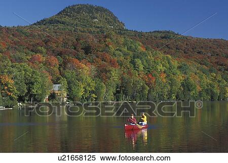 Stock Photography -  canoeing, Vermont, VT, Mother and daughter paddle a red canoe on Long Pond in Westmore in the fall surrounded by colorful foliage. . Fotosearch