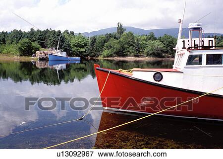 Stock Photo -  Cape Breton, Nova Scotia, NS, Canada, Red and blue lobster boats in Dingwall in Cape Breton.. Fotosearch